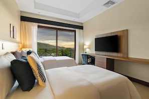 A hotel room with two beds, a TV, a desk, and a balcony with a view. - Hermosa del Mar 1-6B | Ocean Views, Walk to Beach (Playa Hermosa)