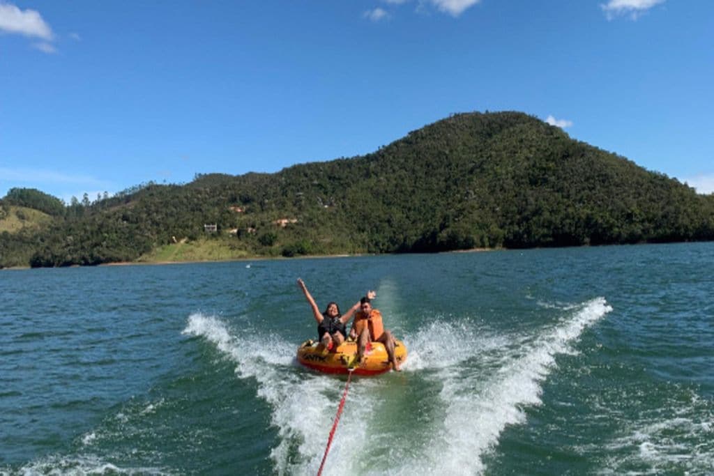 A water sport activity on a lake with a hilly landscape in the background.