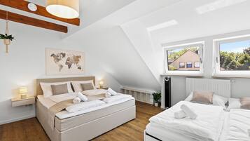 Une chambre à coucher moderne avec un grand lit, une carte du monde accrochée au mur et une vue sur une maison par la fenêtre.