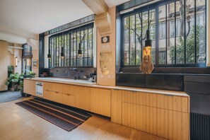 Une cuisine moderne avec des meubles en bois, un four encastré et une grande fenêtre donnant sur la ville.