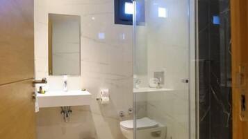 Une salle de bain moderne avec une douche à parois de verre, un lavabo et des toilettes.