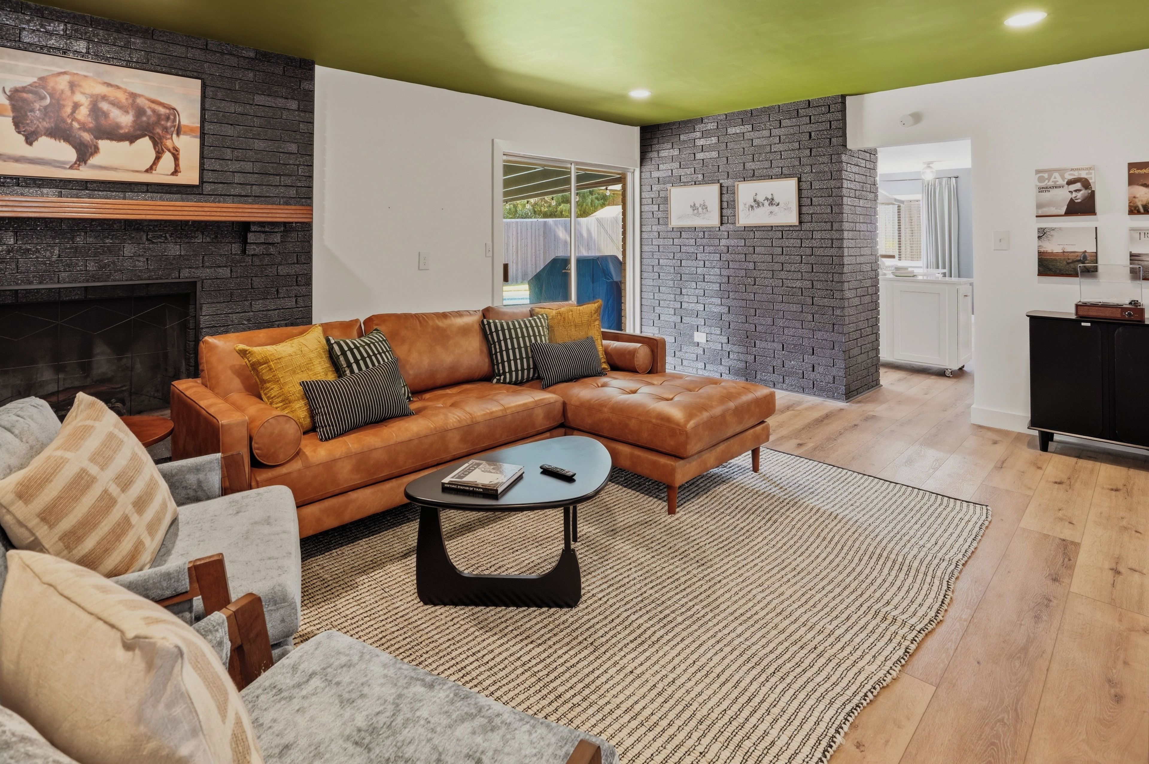 A modern living room with a sectional sofa, a fireplace, and a stone accent wall.
