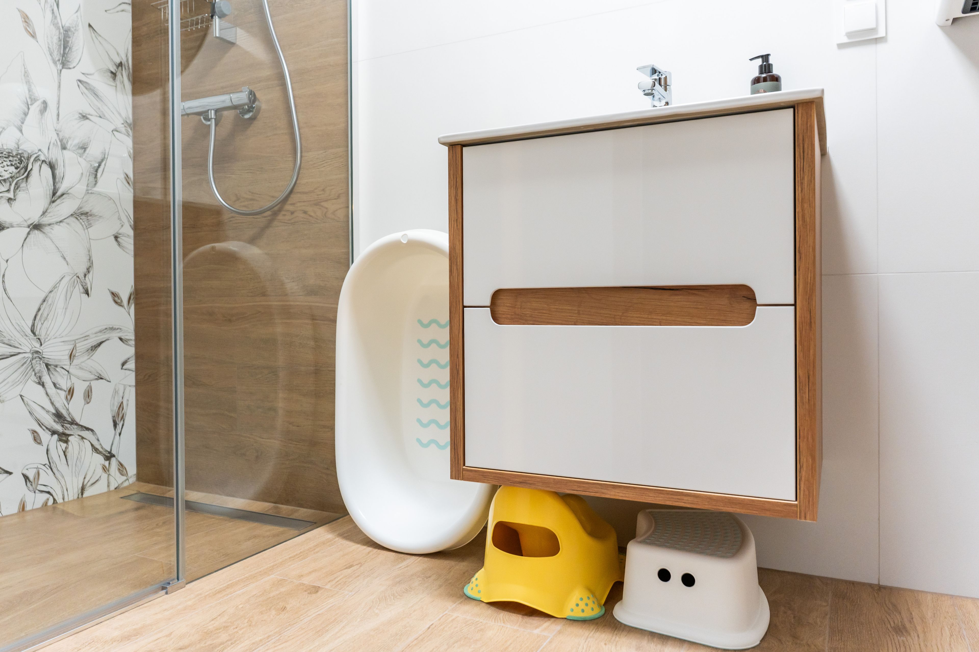 Un bagno con un mobile lavabo in legno, una doccia e un water.