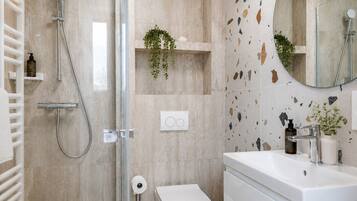 Un bagno moderno con doccia, WC e lavandino.