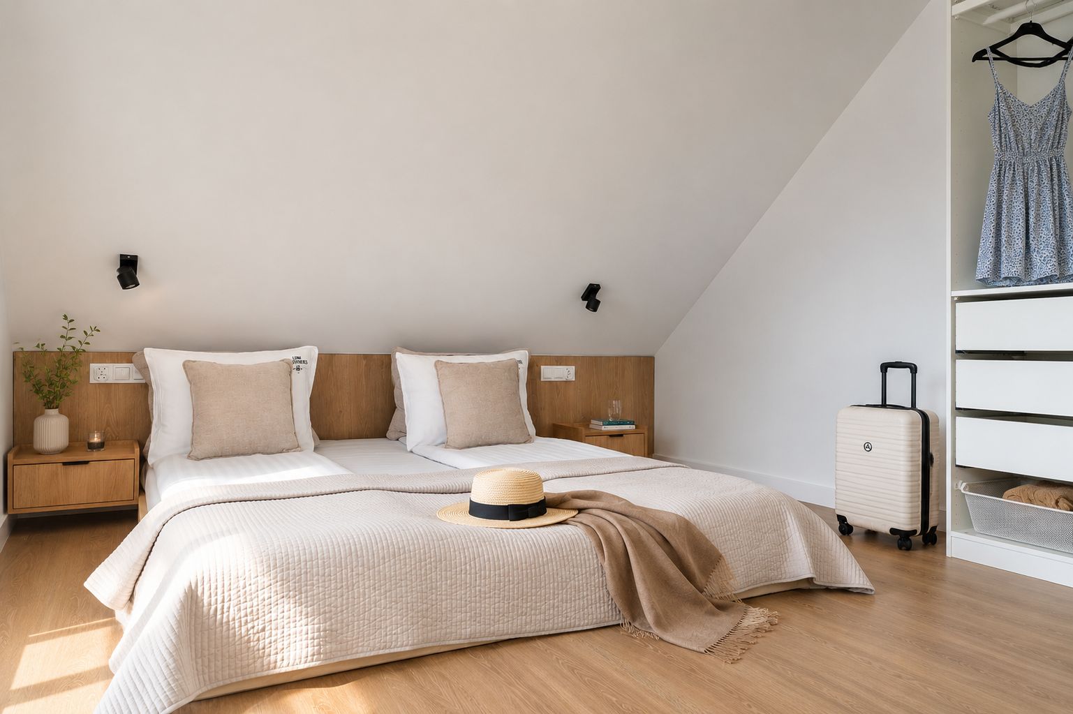 Ein modernes Schlafzimmer mit einem Bett, Nachttischen, einem Koffer und einem Kleiderschrank.