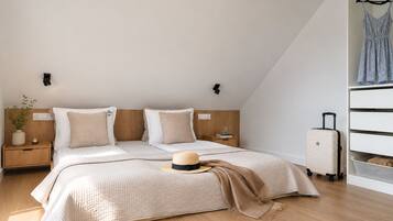 Ein modernes Schlafzimmer mit einem Bett, Nachttischen, einem Koffer und einem Kleiderschrank.