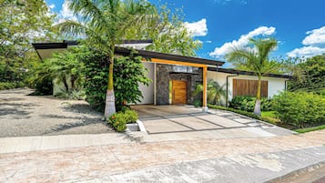 A modern house with a stone facade, a wooden door, and a covered entrance.