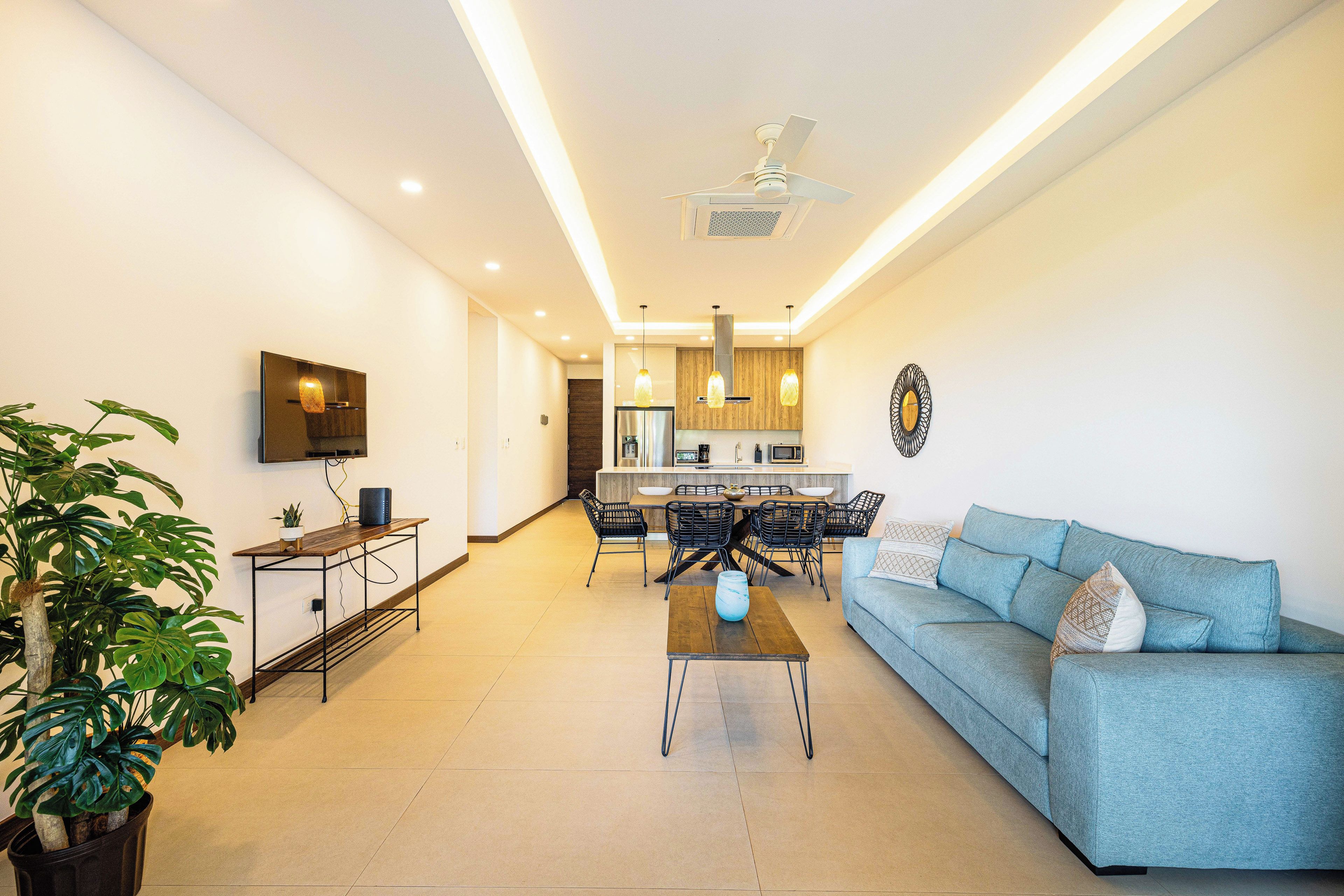 A modern living room with a sofa, coffee table, and dining area.