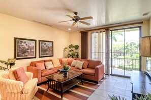 A living room with a sofa, armchairs, a coffee table, and a ceiling fan. - Walkable Coco Beach Condo w/ Balcony, Pool (Sardinal)