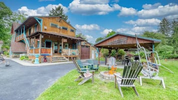 A two-story wooden building with a porch and outdoor seating area.
