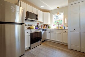 A kitchen with white cabinetry, stainless steel appliances, and a window with a view. - Near Bent's Old Fort: Quiet La Junta Home (La Junta)