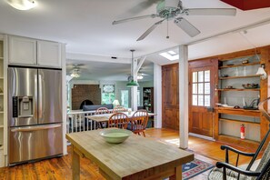 A modern kitchen with a stainless steel refrigerator, wooden dining table, and a ceiling fan. - Historic Streamside Farmhouse in Stroudsburg! (Stroudsburg)