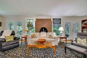 A living room with a fireplace, two sofas, a coffee table, and a bookshelf. - Historic Streamside Farmhouse in Stroudsburg! (Stroudsburg)