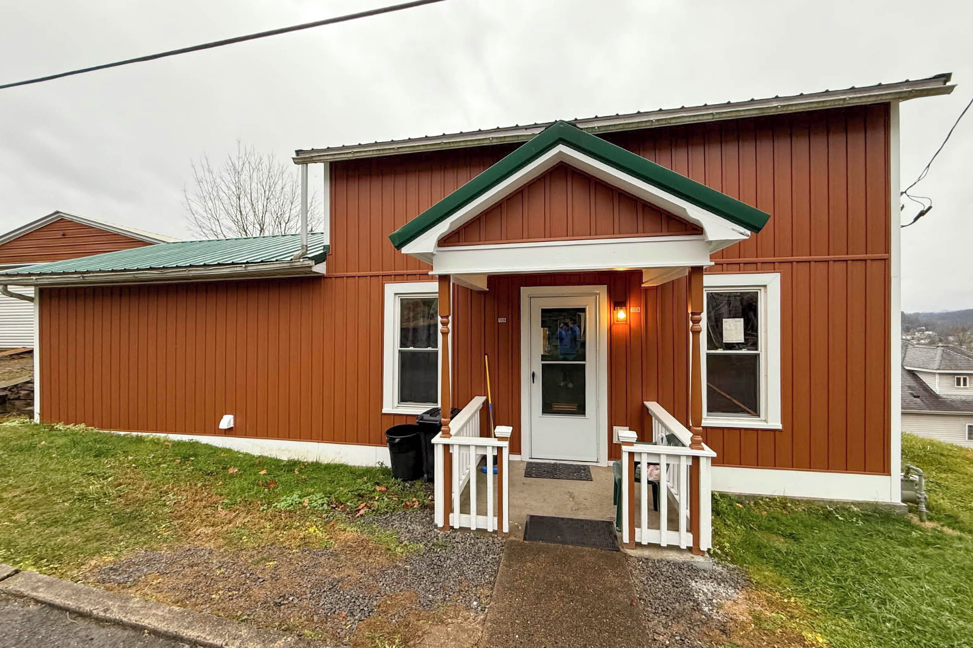 A single-story house with a front porch, a door, and two windows.