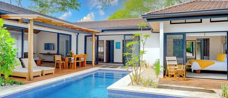 A modern outdoor pool area with a pergola, lounge chairs, and a dining set.