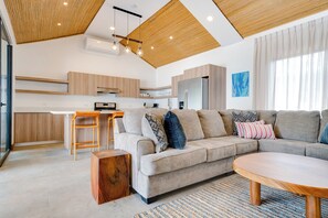 A modern living space with a kitchen, dining area, and seating.