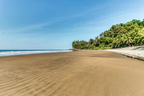 A beach with a clear sky, sandy shore, and dense greenery on the right. - 3 Bungalow Compound! Ojochal Oasis w/ Private Pool (Ciudad Cortés)