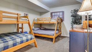 A dormitory room with bunk beds, a desk with a lamp, and a window with a view of mountains. - Hot Tub Ski Home: Rooster's Den in Ellicottville (Ellicottville)