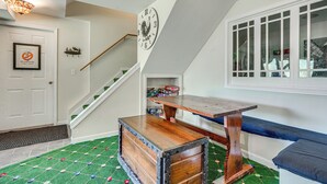 A room with a wooden bench, a clock on the wall, and a staircase. - Hot Tub Ski Home: Rooster's Den in Ellicottville (Ellicottville)