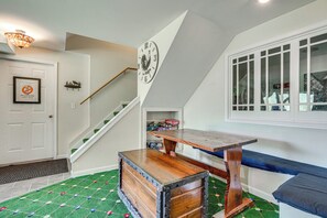 A room with a wooden bench, a clock on the wall, and a staircase. - Hot Tub Ski Home: Rooster's Den in Ellicottville (Ellicottville)