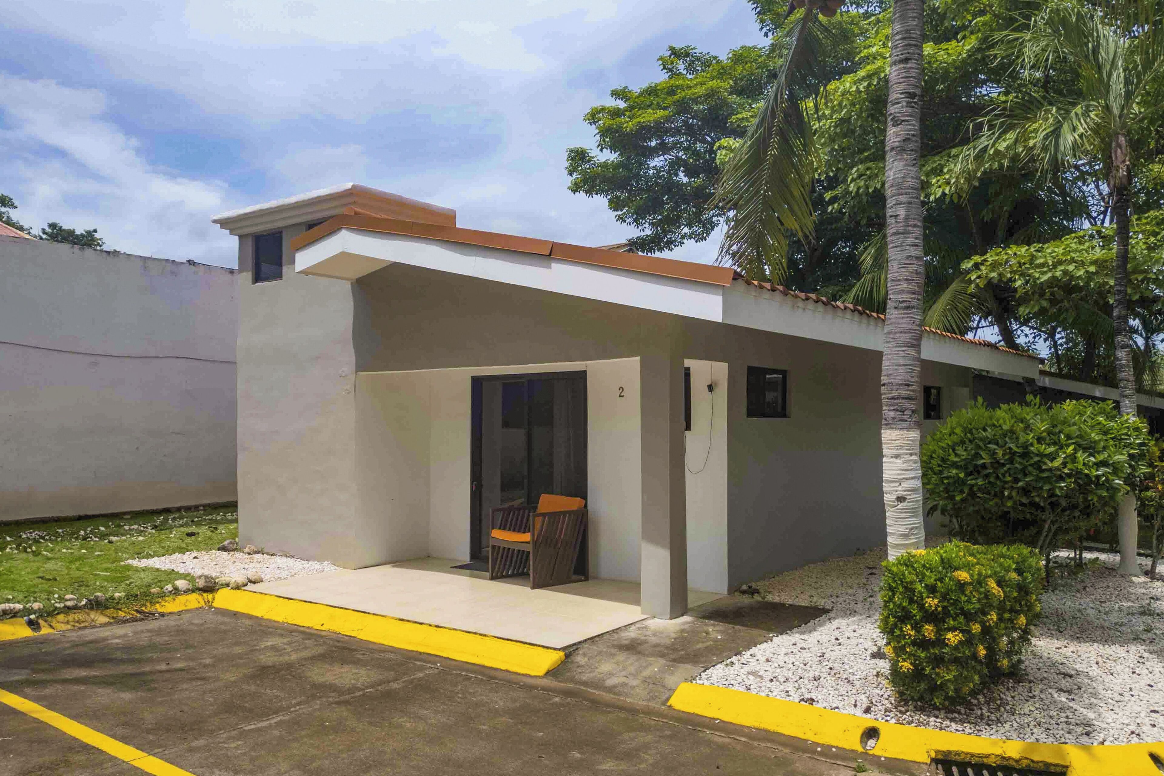 A building with a covered outdoor seating area, a door, and a small window.