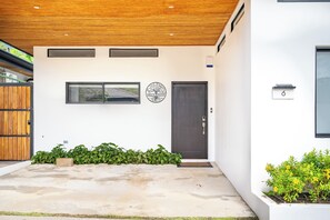 A modern building with a dark door, a window, and a logo on the wall. - Modern Tamarindo Villa Private Pool & Garden (Tamarindo)