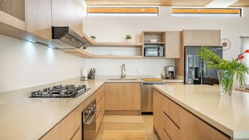 A modern kitchen with wooden cabinets, a gas stove, a microwave, a refrigerator, and a sink.
