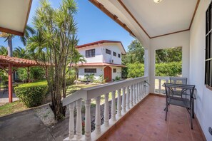 A covered outdoor area with a white railing, a patio table, and chairs. - Santa Cruz Group Getaway w/ Pool: Walk to Beach (Veintisiete de Abril)
