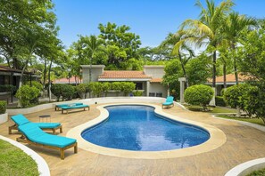 A swimming pool with lounge chairs and a small building in a landscaped area. - Ground-floor Studio w/ Pool Access, Walk to Beach! (Sardinal)