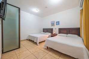 A hotel room with two beds, a TV, and a small table with a lamp. - 1 Mi to Beach: Playas del Coco Condo w/ Pool (Sardinal)