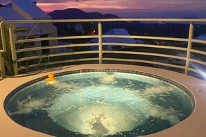 A hot tub with a view of mountains at dusk.