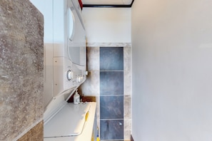 A bathroom with a white sink, a mirror, and a tiled floor.