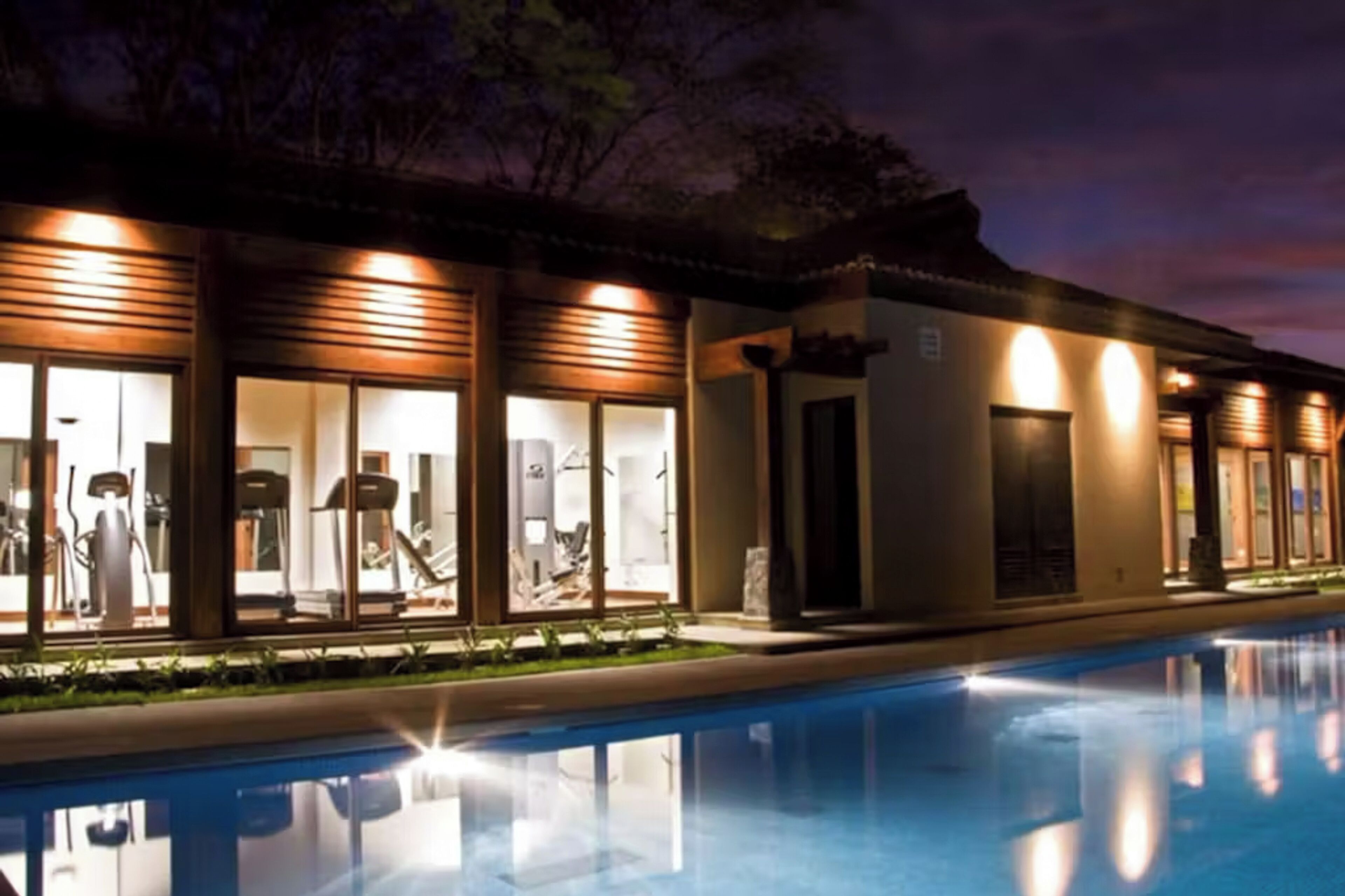 Un hotel con piscina, amplias ventanas y fachada bien iluminada.