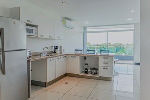 A modern kitchen with a built-in microwave, coffee maker, and a blender on the counter. - Ocean-view Stay, El Roble Marina & Pool Access (Puntarenas)