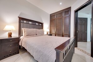 A bedroom with a bed, nightstands, a wardrobe, and a door. - 4 Mi to Beach! Playa Grande Apartment (Cabo Velas)