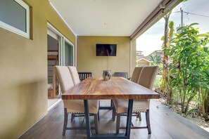 A dining area with a wooden table, four chairs, and a television mounted on the wall. - 4 Mi to Beach! Playa Grande Apartment (Cabo Velas)
