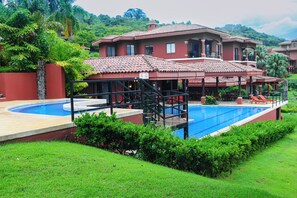 Un resort con piscina, zona de estar al aire libre y exuberante vegetación.