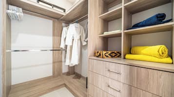 A walk-in closet with wooden shelving, a hanging rod, and a built-in wardrobe.