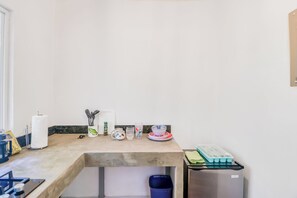 Eine Küche mit Arbeitsplatte, Herd, Mülleimer und Kühlschrank.