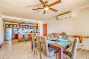 A spacious kitchen with a dining area, wooden cabinets, and a ceiling fan. - Ocean Views: Bahia Pez Vela Resort Condo (Sardinal)