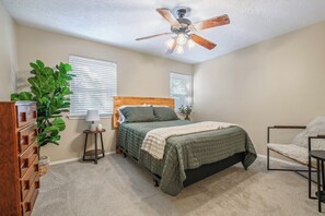 A bedroom with a bed, a dresser, a plant, and a ceiling fan. - 2 Mi to Campus! College Station Condo w/ Pool (College Station)