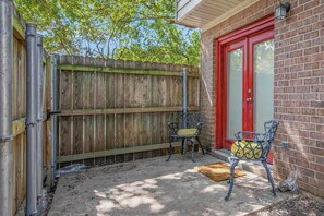 A fenced outdoor area with a bench and a door to a building. - 2 Mi to Campus! College Station Condo w/ Pool (College Station)