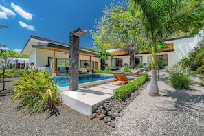 A modern house with a swimming pool, outdoor seating, and a well-maintained garden. - Tamarindo Home w/ Pool, 2 Mi to Beach! (Tamarindo)