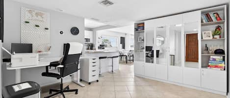 A modern office space with a desk, chair, and shelving units.