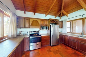 A kitchen with wooden cabinets, a stainless steel refrigerator, an oven, and a microwave. - Mtn-view Farmhouse w/ Pool in Atenas (San José)