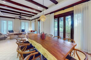 A spacious dining area with a wooden table, chairs, and a ceiling fan.