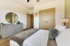 A bedroom with a bed, dresser, mirror, and a door leading to another room. - On 5+ Acres! Quiet Spring Branch Retreat w/ Views (Spring Branch)