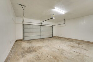 Eine Garage mit geschlossenem Rolltor, Neonbeleuchtung und einem Betonboden.