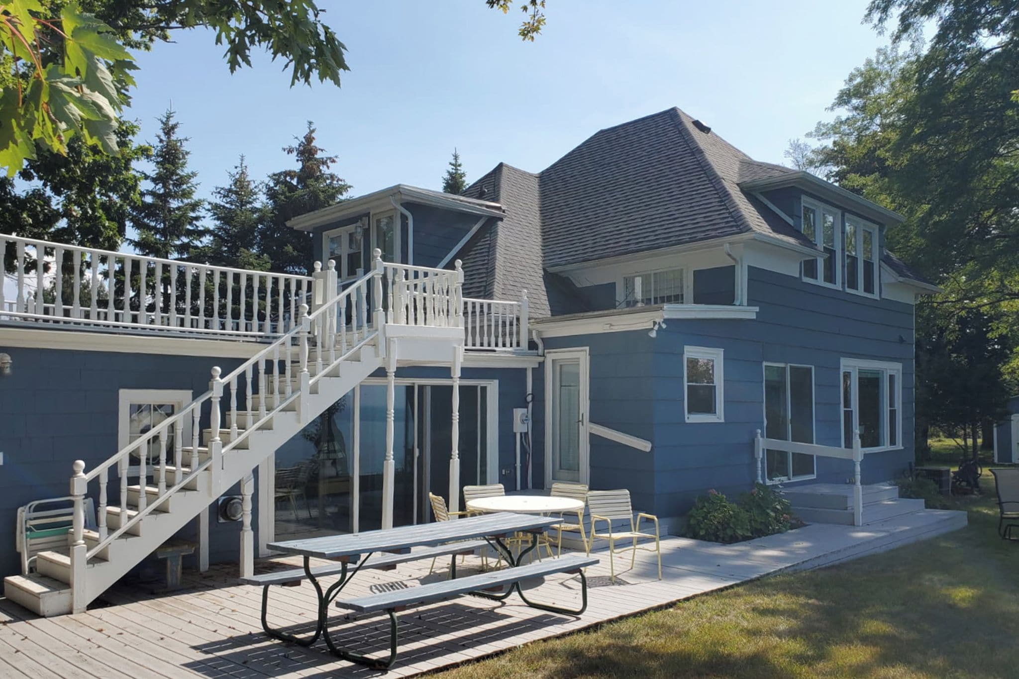 A two-story house with a covered patio, a staircase, and a dining area.