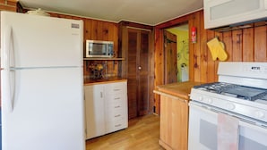 A compact kitchen with a refrigerator, microwave, stove, and wooden cabinets. - Carley House Too: Pet Friendly, Hot Tub, Fire Pit! (Ellicottville)